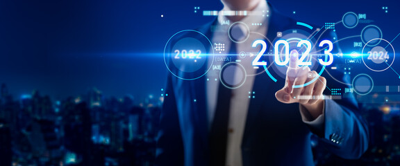 Smart businessman pointing digital dashboard in 2022 on hologram blue background.Artificial...