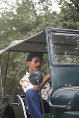 man with mustcahes sitting in vintage car