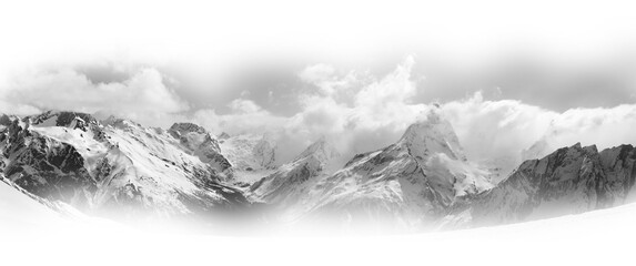 Panorama of snowy mountain peaks in sunlight clouds