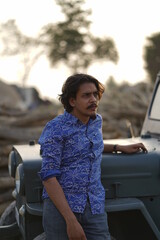 Fototapeta premium man with long hair posing with a jeep