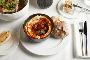dish of hummus with roasted peppers top view