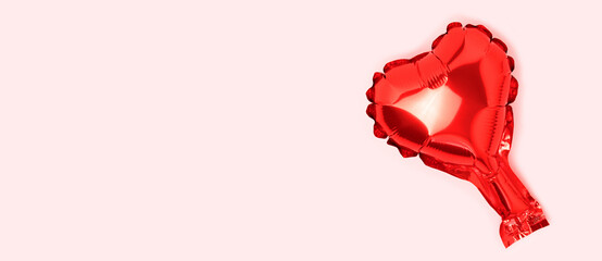 Banner wit red heart foil balloon. Minimal festive composition on a pink background.