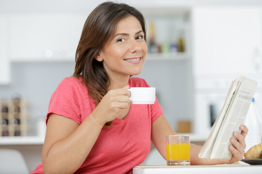 woman catching up on currect affairs while drinking a coffee