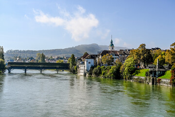 Fototapeta premium Olten, Stadt, Stadtturm, Aare, Fluss, Alte Brücke, Holzbrücke, Altstadt, historische Häuser, Bahnhof, Herbst, Herbstsonne, Herbstfarbe, Solothurn, Schweiz