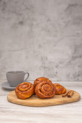 Sweet rolls with cinnamon on wooden board. Caramel buns with nuts.