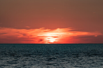 The Sun setting behind the clouds on the horizon of the Delaware Bay.