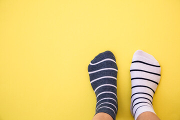 Odd socks day concept. Legs in different socks on a blue background. Top view.
