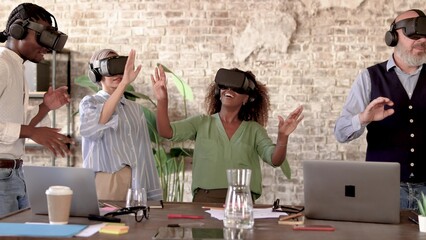 Group of coworkers testing a project in metaverse virtual reality wearing 3d googles and having fun together