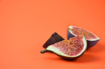 Pieces of figs on an orange background.