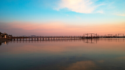 Wooden jetty on Carmoli beach at a beautiful and colorful sunrise, in Cartagena, Region of Murcia, Spain