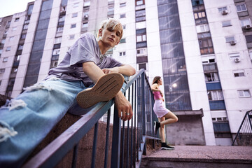 Teenage couple hanging out outside in urban exterior.