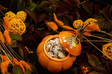 Thanksgiving Autumn festive table background with pumpkin top view branches of sea buckthorn berries a pumpkin-shaped pot with sponge cake surrounded by dried leaves and flowers 