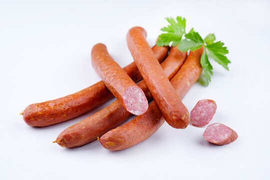 Traditionelle rohe &ouml;sterreichische feine K&auml;sewurst mit K&auml;se angeboten als close-up auf wei&szlig;em Hintergrund und Petersilie mit Textfreiraum 