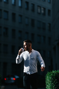the person walking with coffee. Businessman walking