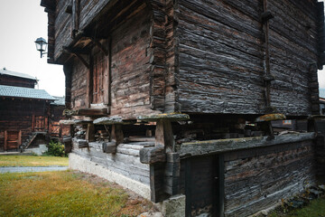Fototapeta na wymiar Ancient wooden traditional Swiss raccard granary on stone piles in old Hinterdorf quarter of Zermatt Switzerland, Rainy weather.