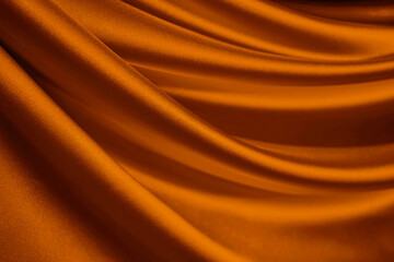 Dark orange brown silk satin. Drapery fabric. Curtain. Luxury background for design. Beautiful soft folds. Wavy lines. Golden color. Christmas, birthday, Mother's day, Valentine.