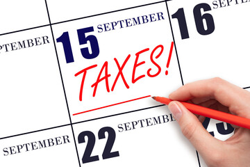 Hand drawing red line and writing the text Taxes on calendar date September 15. Remind date of tax...
