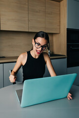 Изображение молодой довольной счастливой веселой милой красивой деловой женщины сидят в помещении в офисе, используя ноутбук