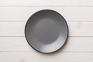 Top view of empty grey plate on wooden background. Empty space for your design
