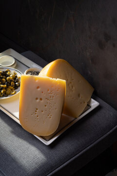 Sliced Head Of Cheese On A Dark Background