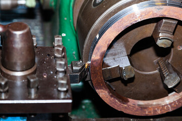 Turning a steel billet on a lathe with a cutter.