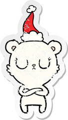 peaceful hand drawn distressed sticker cartoon of a polar bear wearing santa hat