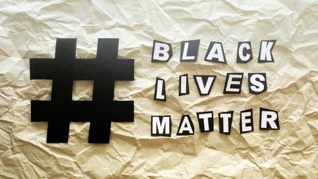 Black lives matter paper letter cutouts with hashtag on a crumpled paper background
