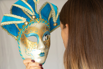 The face of a girl in a Venetian carnival mask on an isolated background, masquerade and masked...