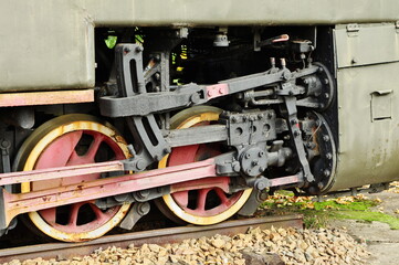 Fototapeta na wymiar Historic railway. Old steam locomotive. A part of the suspension. Wheels and pistons are visible.