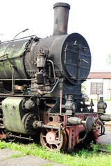 Historic railway.The front part of a steam locomotive. A fragment of the boiler, wheels, pistons, lantern and bumper are visible.