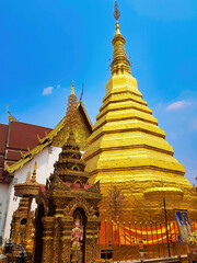 The 14-th century chedi (dagoba), covered in gilded copper plates, of the buddhist temple Wat Phra That Cho Hae in the town of Phrae, Northern Thailand