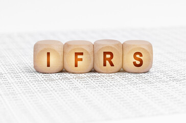 On the table with documents are wooden cubes with the inscription - IFRS