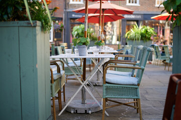 empty tables and large umbrella / Parasol at cafe with plants and glass cups