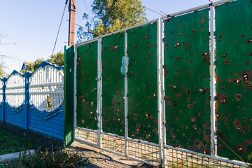 War in Ukraine. 2022 Russian invasion of Ukraine. Countryside. Damaged fence near the house. There...