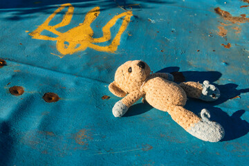 War in Ukraine. 2022 Russian invasion of Ukraine. A toy (teddy bear) lies on a damaged fence with...