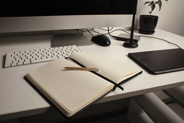 Comfortable place of work. Close-up top view of comfortable working place in office with and laptop. Workplace of designer. Notebook on the table. Business diary. Work at home. Place for making art.