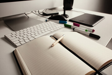 Comfortable place of work. Close-up top view of comfortable working place in office with and laptop. Workplace of designer. Notebook on the table. Business diary. Work at home. Place for making art.