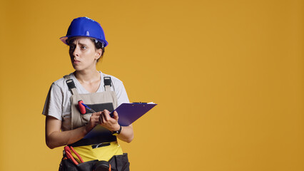 Portrait of construction worker taking notes and doing architecture measurement, writing and...