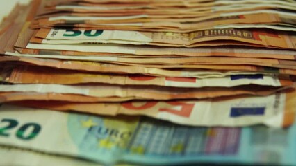 Video of 50 and 20 euro bills stacked and lined up, passing from top to bottom.