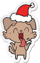 hand drawn sticker cartoon of a panting dog shrugging shoulders wearing santa hat