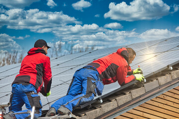 Installing solar photovoltaic panel system. Solar panel technician installing solar panels on roof. Alternative energy ecological concept.
 - obrazy, fototapety, plakaty