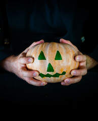 Hombre disfrazado para halloween con una calabaza en la mano