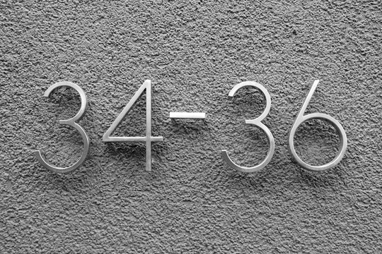 Hausnummer 34-36 in elegantem Design auf Rauputz in der Schweizer Stra&szlig;e im Stadtteil Sachsenhausen in Frankfurt am Main in Hessen in neorealistischem Schwarzwei&szlig;