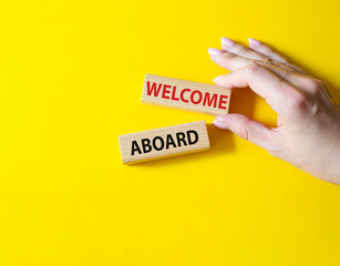 Welcome aboard symbol. Concept word Welcome aboard on wooden blocks. Beautiful yellow background. Businessman hand. Business and Welcome aboard concept. Copy space