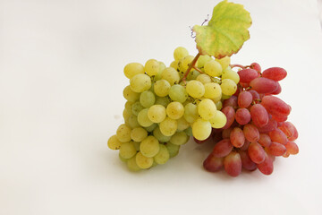 a bunch of red grapes and a bunch of green grapes on a white background