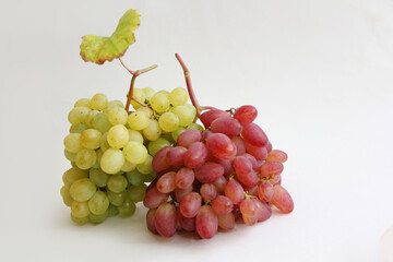 a bunch of red grapes and a bunch of green grapes on a white background