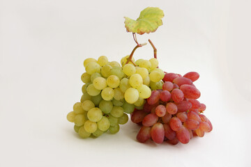 a bunch of red grapes and a bunch of green grapes on a white background