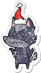 angry wolf hand drawn distressed sticker cartoon of a wearing santa hat