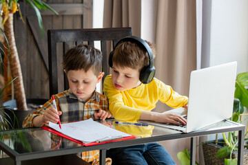 Preschooler boy and schoolboy make together a homework at home