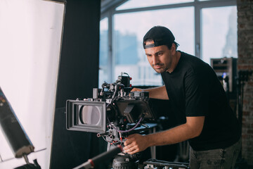 Director of photography with a camera in his hands on the set.  Filming process indoors, studio